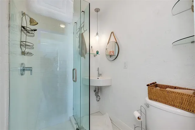 a view of a white house with wooden fence and a large tree