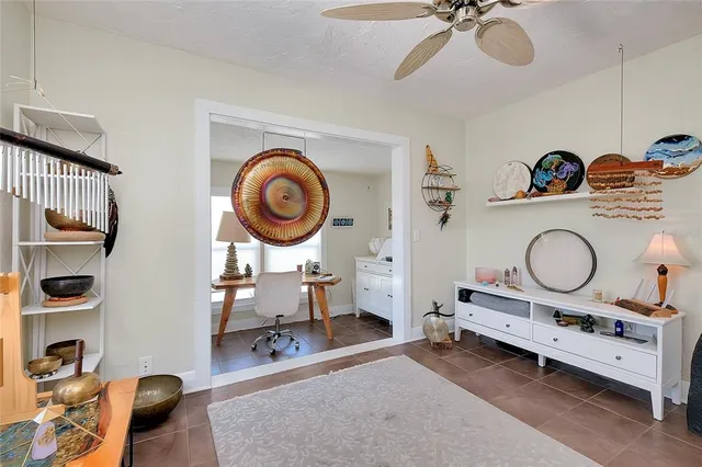 a view of a white house with a small yard and potted plants
