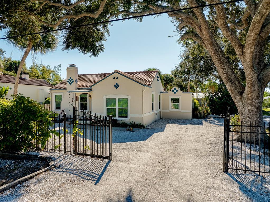 223 Palmetto Road West Nokomis, FL 34275 - Photo 90 of 100 a view of a white house with wooden fence and a large tree