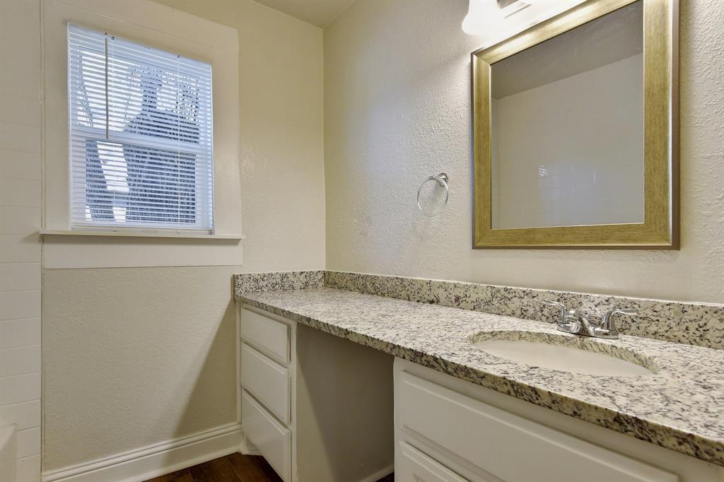 1115 South Rusk Avenue Denison, TX 75020 - Photo 13 of 21 a bathroom with a granite countertop sink and a mirror