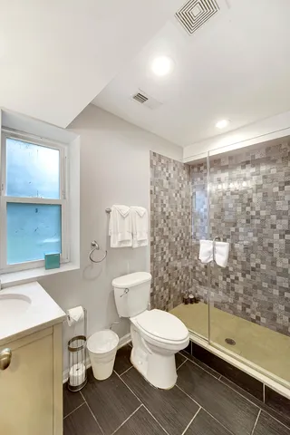 a white toilet sitting next to a bathroom sink