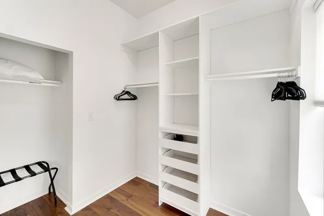 a view of walk in closet with empty racks