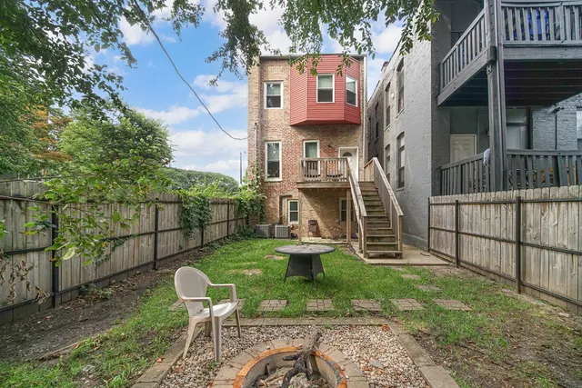 a view of a chair and table in backyard of the house