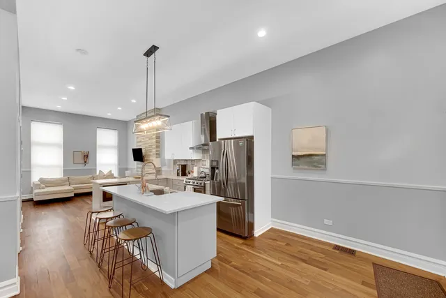 a kitchen with stainless steel appliances granite countertop a sink refrigerator and microwave