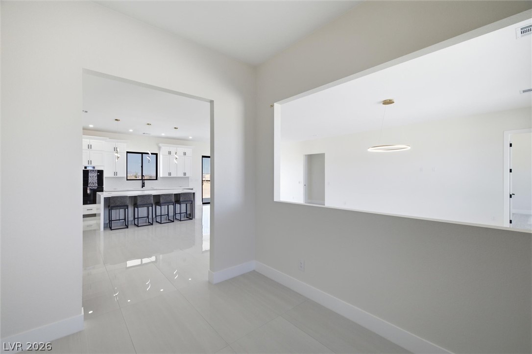 5910 East Kellogg Road Pahrump, NV 89061 - Photo 7 of 58 Clean lines and glossy tile flooring define this modern open-concept space.