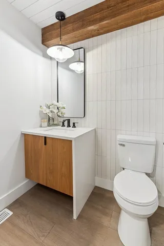 a bathroom with a sink a toilet and mirror