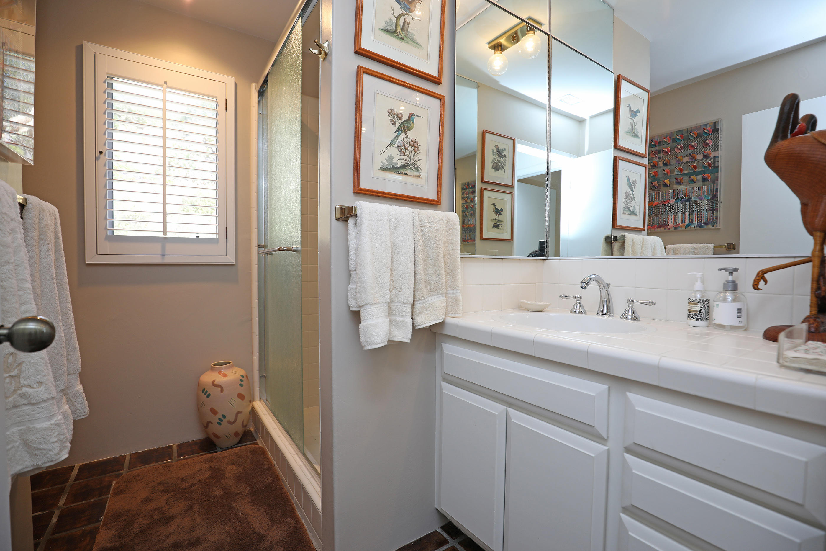 1986 Arriba Street Carpinteria, CA 93013 - Photo 22 of 35 a bathroom with a granite countertop sink a mirror and a shower
