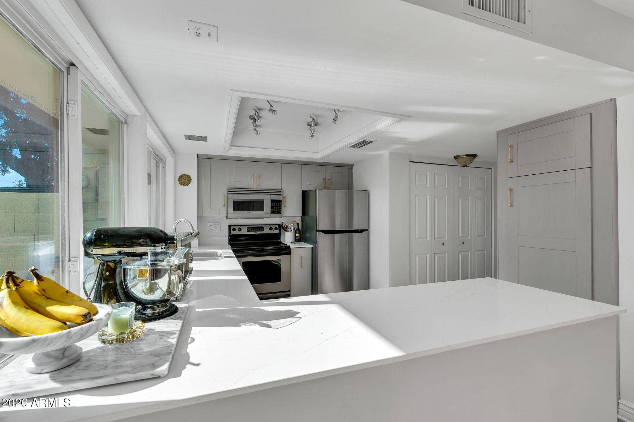 4217 North Miller Road Scottsdale, AZ 85251 - Photo 11 of 30 a kitchen with stainless steel appliances kitchen island granite countertop a refrigerator and a stove top oven