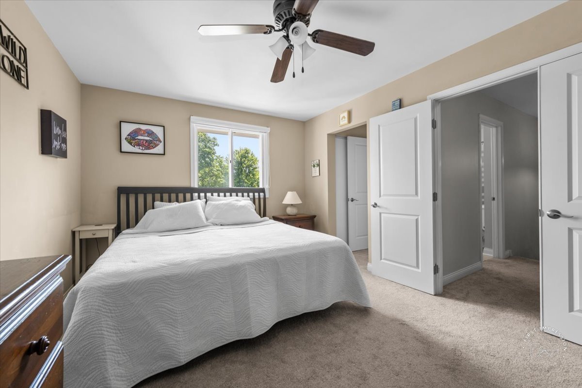 1015 Heathrow Court Wheaton, IL 60189 - Photo 14 of 18 a bedroom with a bed and a chandelier