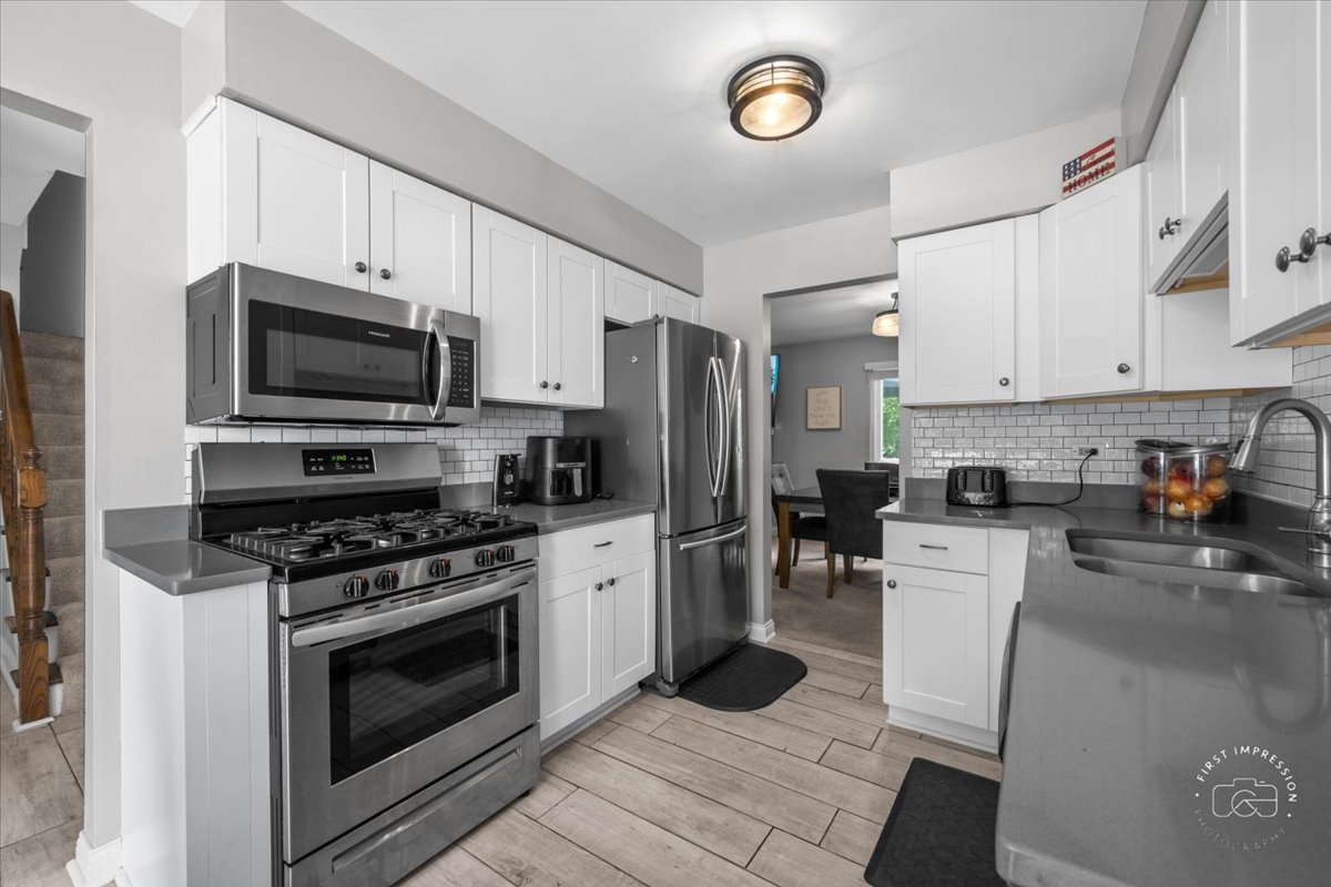1015 Heathrow Court Wheaton, IL 60189 - Photo 4 of 18 a kitchen with stainless steel appliances a stove a sink cabinets and a refrigerator