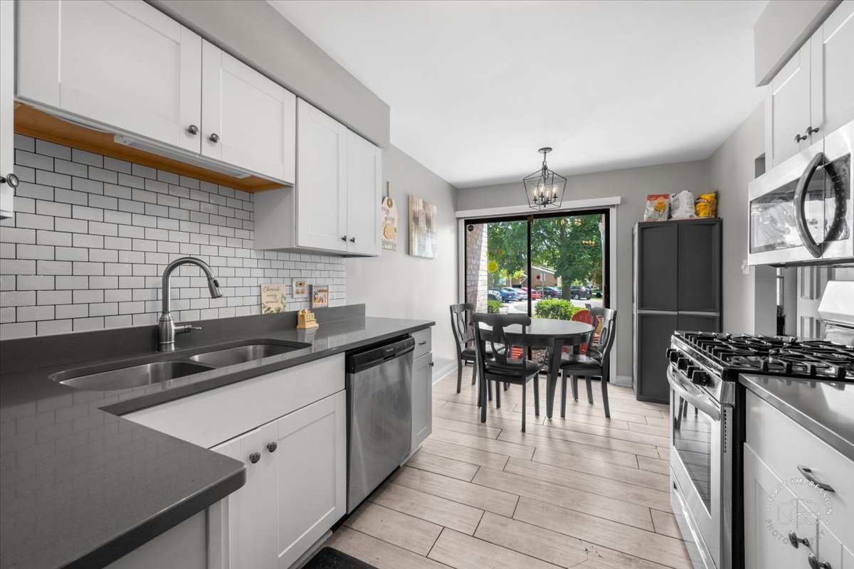 1015 Heathrow Court Wheaton, IL 60189 - Photo 5 of 18 a kitchen with granite countertop a sink stove and cabinets