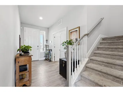 a hallway with wooden floor and a potted plant