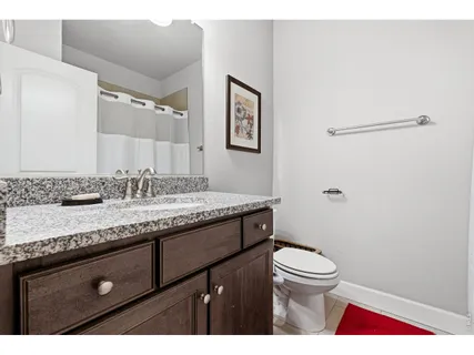 a bathroom with a granite countertop sink a toilet and a mirror