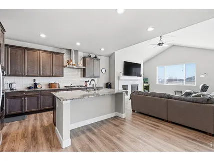 a large kitchen with cabinets wooden floor and stainless steel appliances