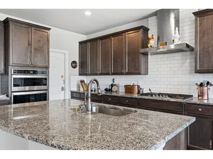 a kitchen with stainless steel appliances granite countertop a stove a sink and a microwave