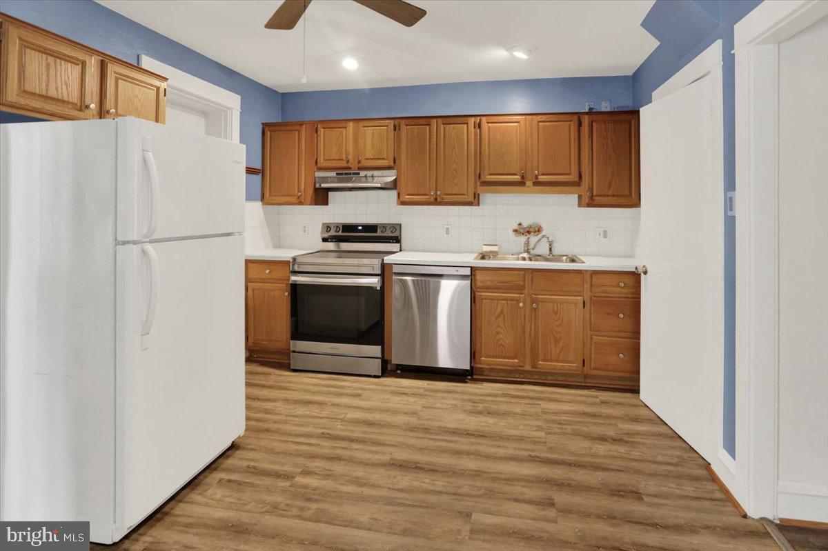 29 Arlington Street Reading, PA 19611 - Photo 10 of 32 a kitchen with stainless steel appliances granite countertop a refrigerator a sink dishwasher a stove with wooden cabinets and floor