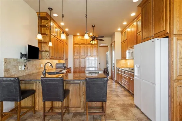 a kitchen with stainless steel appliances granite countertop a sink a stove and a refrigerator