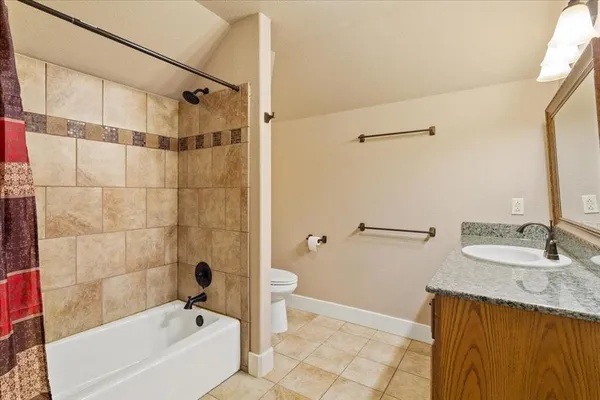 a bathroom with a granite countertop sink a mirror a shower and vanity