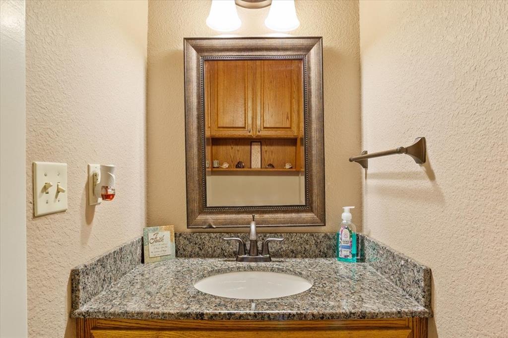 10479 Hartrick Bluff Road Little River-Academy, TX 76554 - Photo 33 of 40 a bathroom with a granite countertop sink and a mirror