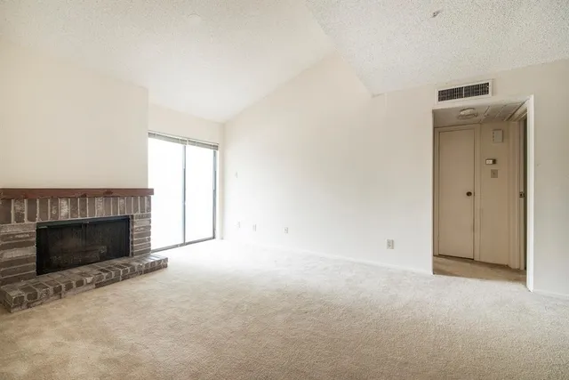 a view of empty room with a fireplace