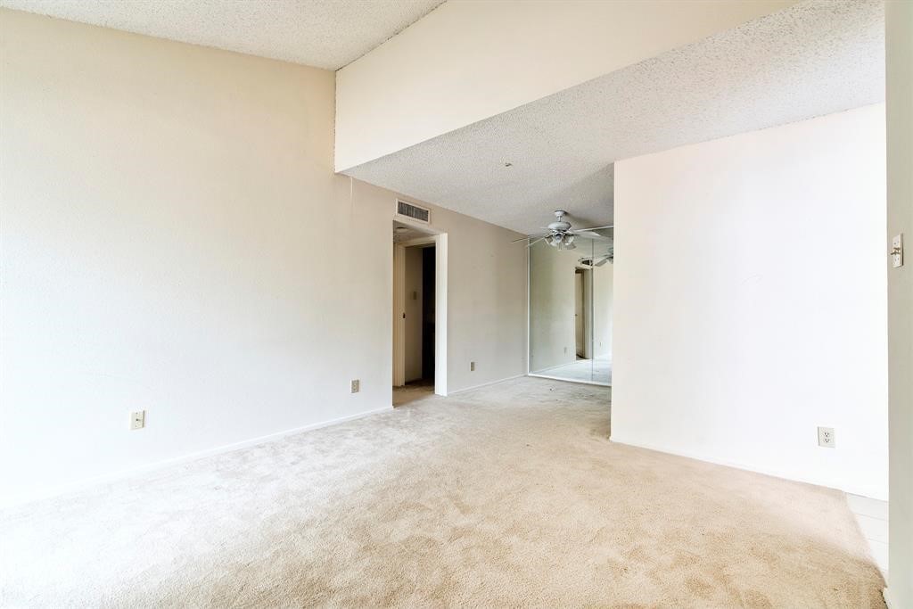 7900 North Stadium Drive, Unit 22 Houston, TX 77030 - Photo 10 of 12 This room features neutral carpet and walls, creating a bright, open space. It includes a ceiling fan and mirrored closet doors, enhancing the sense of space and light.