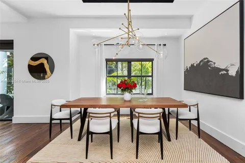 a kitchen with stainless steel appliances granite countertop a stove a refrigerator a oven with white cabinets and wooden floor