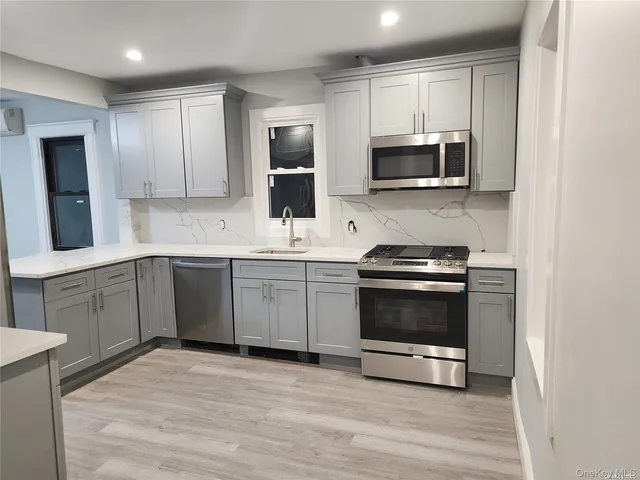 a kitchen with stainless steel appliances a stove microwave and sink