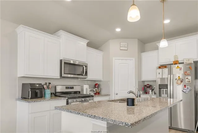 a kitchen with stainless steel appliances granite countertop a sink stove and refrigerator