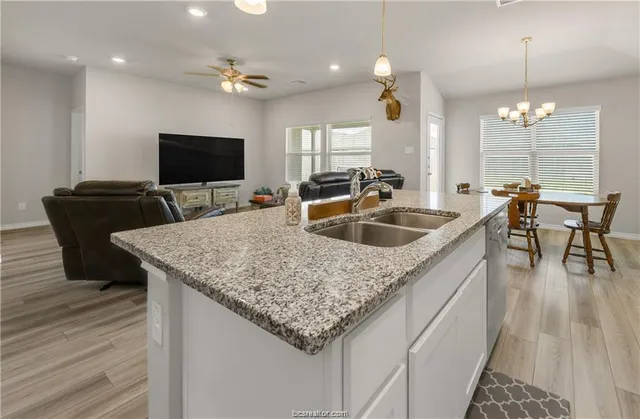 a kitchen with granite countertop a sink and a wooden floor