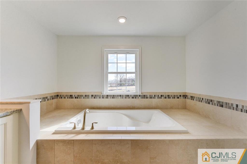 10 May Road East Brunswick, NJ 08816 - Photo 15 of 24 a bathroom with a bathtub and a window