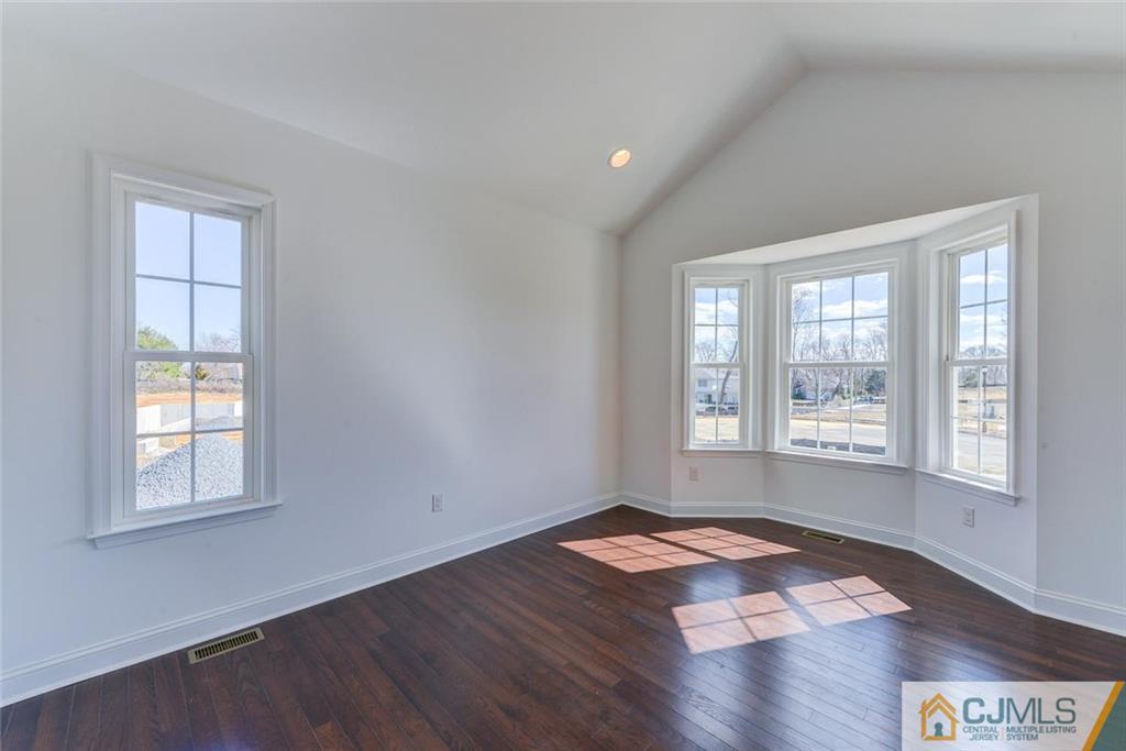 10 May Road East Brunswick, NJ 08816 - Photo 5 of 24 a view of an empty room with wooden floor and a window