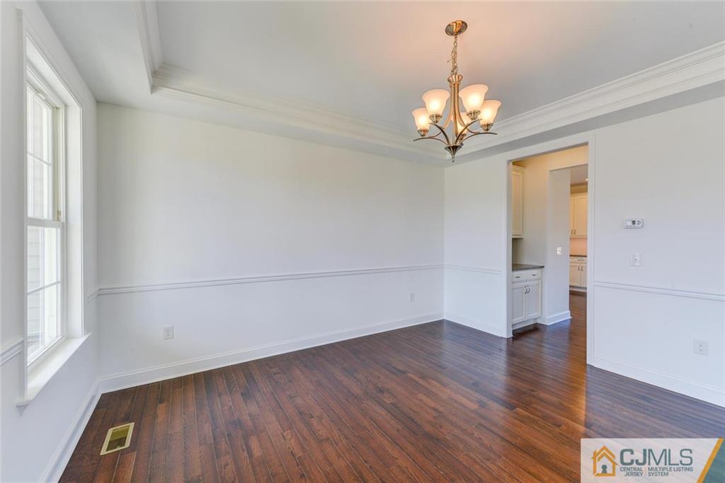 10 May Road East Brunswick, NJ 08816 - Photo 6 of 24 a view of a room with wooden floor and chandelier