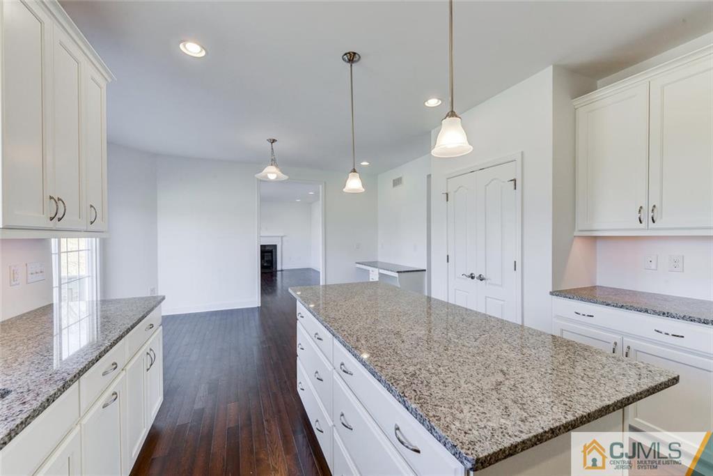 10 May Road East Brunswick, NJ 08816 - Photo 9 of 24 a kitchen with kitchen island a sink stove and wooden floor