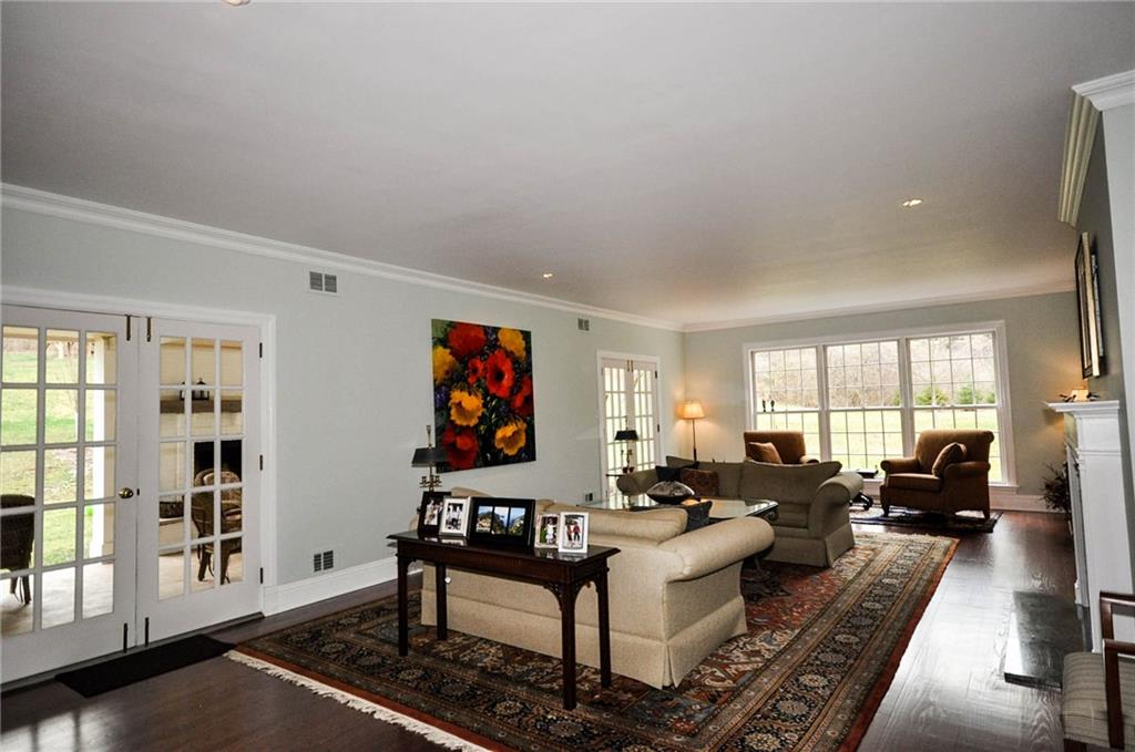 815 Fox Chapel Road Fox Chapel, PA 15238 - Photo 3 of 25 The comfortable living room allows for easy access to the large covered patio through the double french doors The log burning fireplace is a great feature and keeps the massive area cozy in the cold weather season. Beautiful hardwood floors and soft shades are highlighted with custom trim adding to the design.