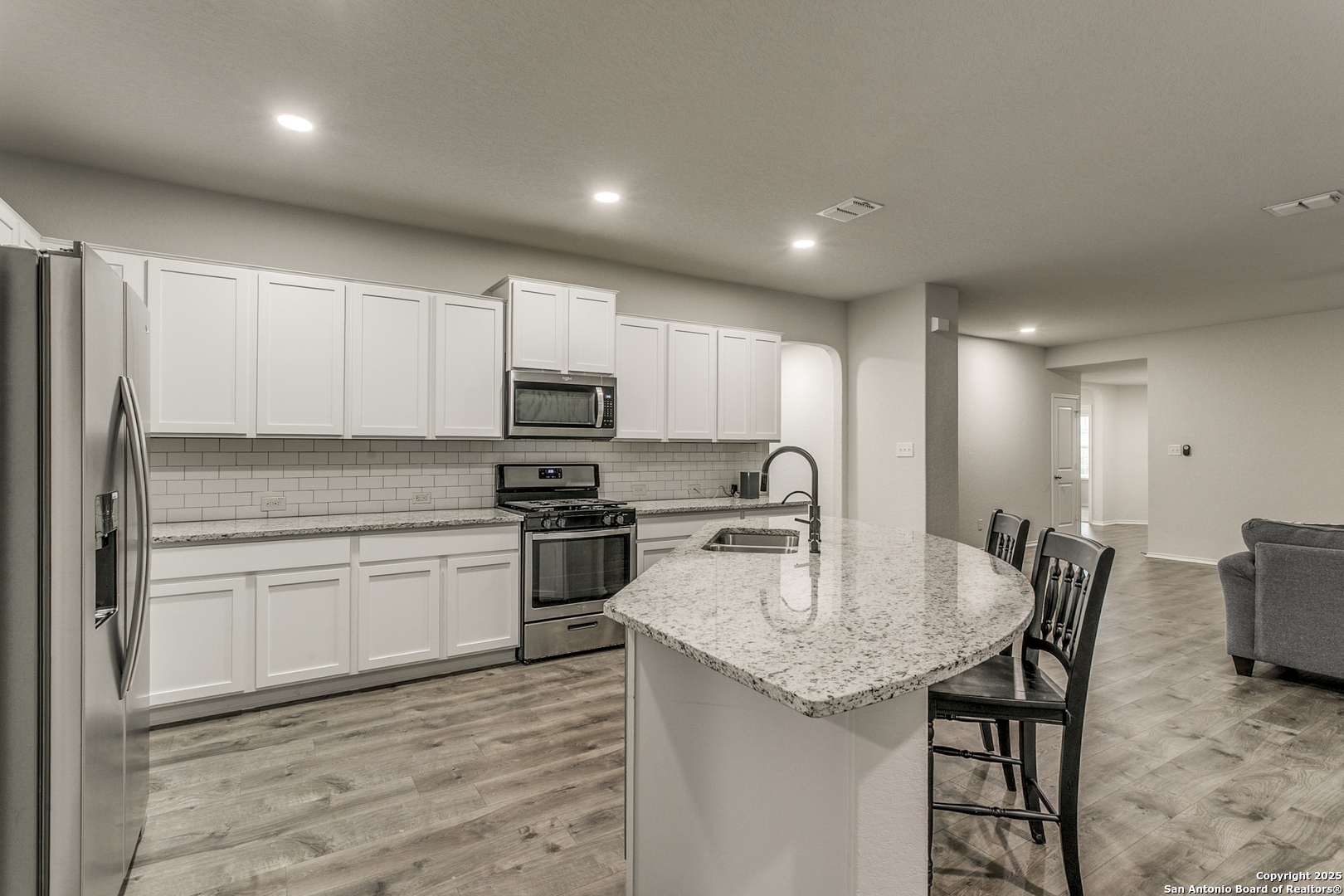 29632 Winter Copper Bulverde, TX 78163 - Photo 11 of 26 a kitchen with stainless steel appliances granite countertop a kitchen island hardwood floor sink and stove