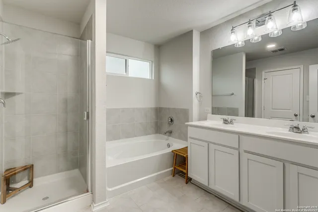 a bathroom with a tub sink shower and mirror