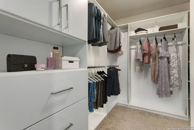 a view of walk in closet with clothes and shoes