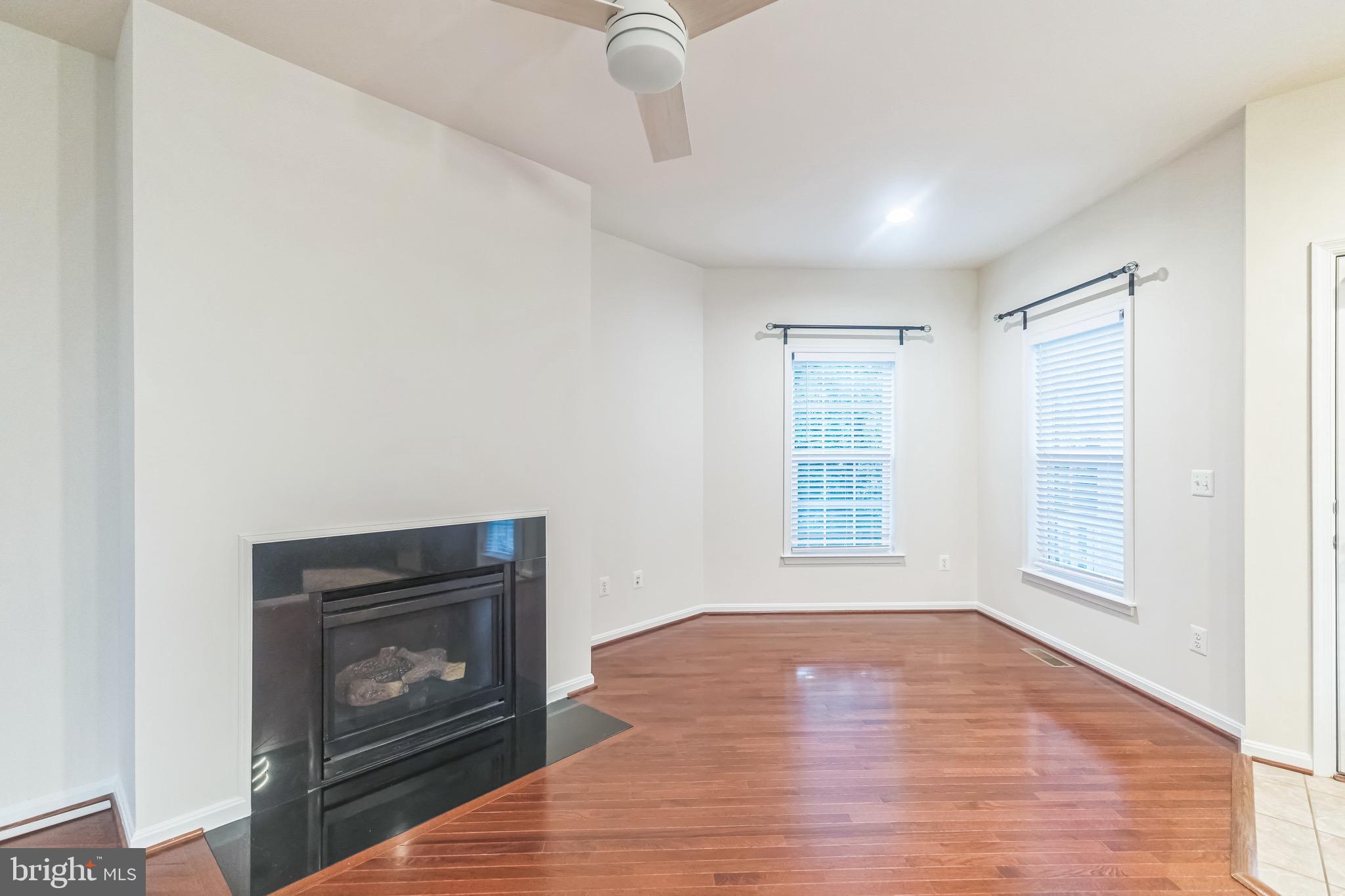 42385 Trellis Square Brambleton, VA 20148 - Photo 10 of 28 a view of an empty room with wooden floor fireplace and a window