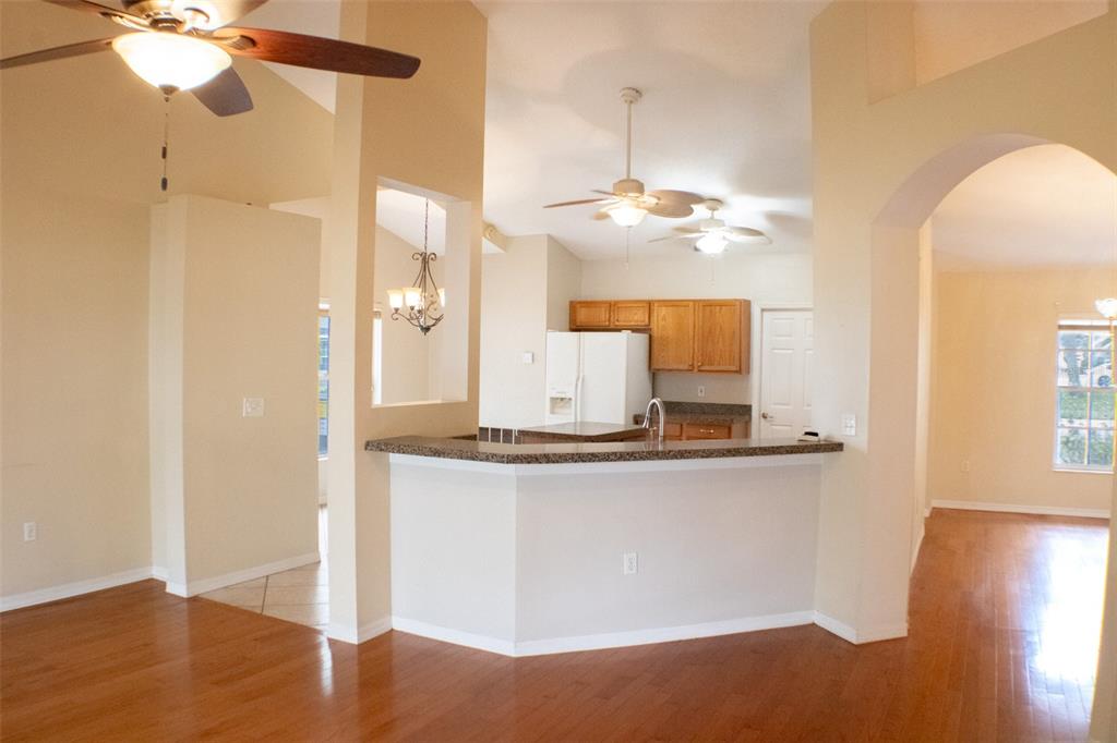 601 Shady Point Way Deland, FL 32724 - Photo 14 of 33 a view of a kitchen with granite countertop a sink and dishwasher a refrigerator with wooden floor