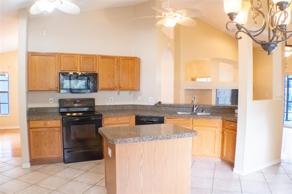 601 Shady Point Way Deland, FL 32724 - Photo 17 of 33 a kitchen with stainless steel appliances granite countertop a stove a sink and a microwave