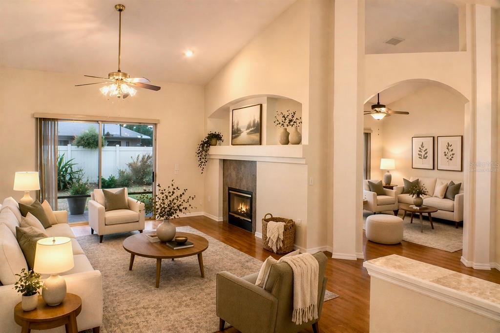 601 Shady Point Way DeLand, FL 32724 - Photo 3 of 36 a living room with furniture a fireplace and a chandelier