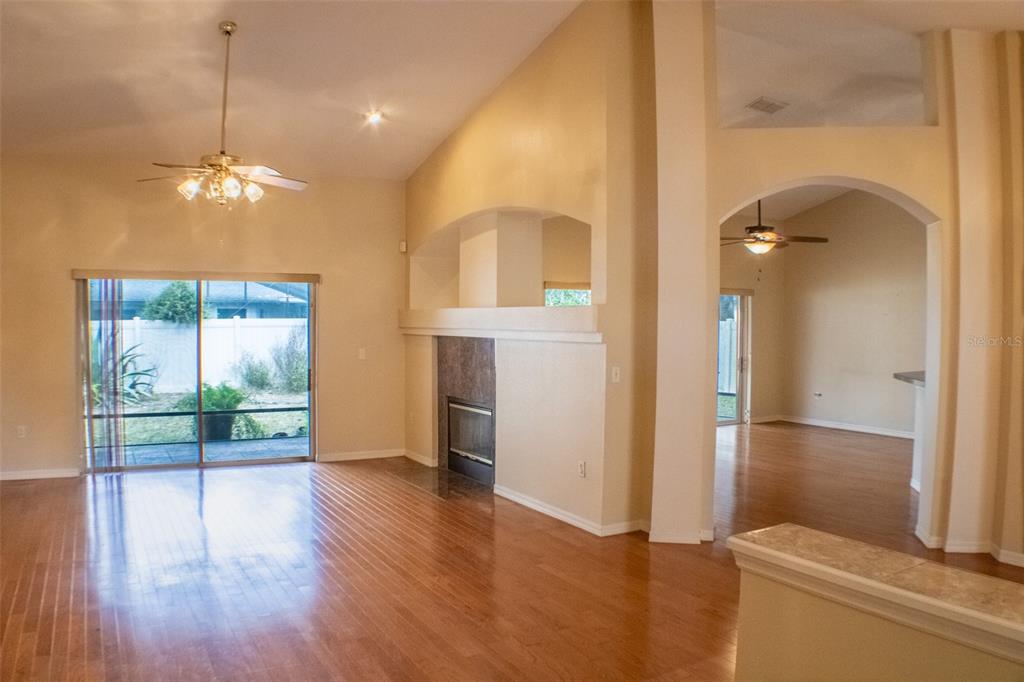 601 Shady Point Way DeLand, FL 32724 - Photo 7 of 36 a view of a room with wooden floor chandeliers and kitchen view