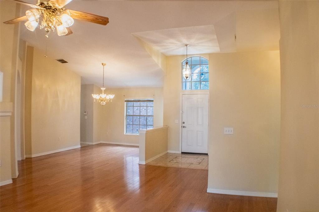 601 Shady Point Way Deland, FL 32724 - Photo 9 of 33 a view of an empty room with window and wooden floor