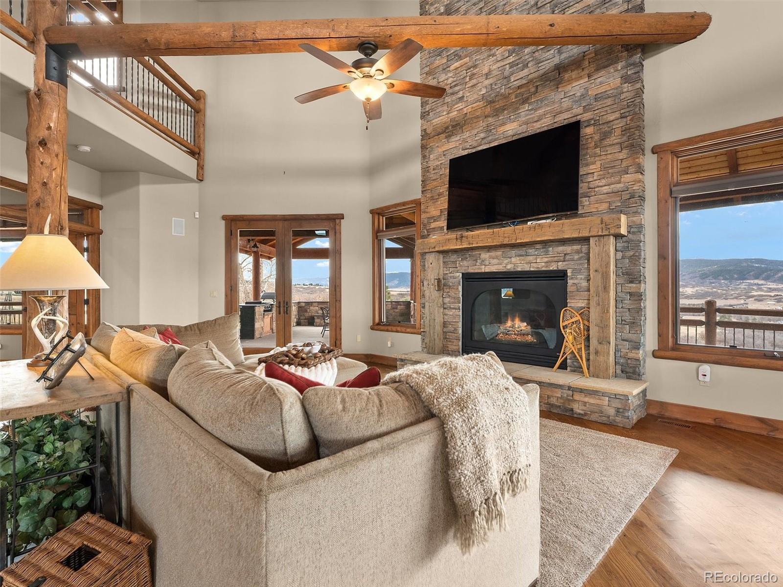 934 South Perry Park Road Sedalia, CO 80135 - Photo 17 of 48 a living room with furniture a fireplace and a flat screen tv