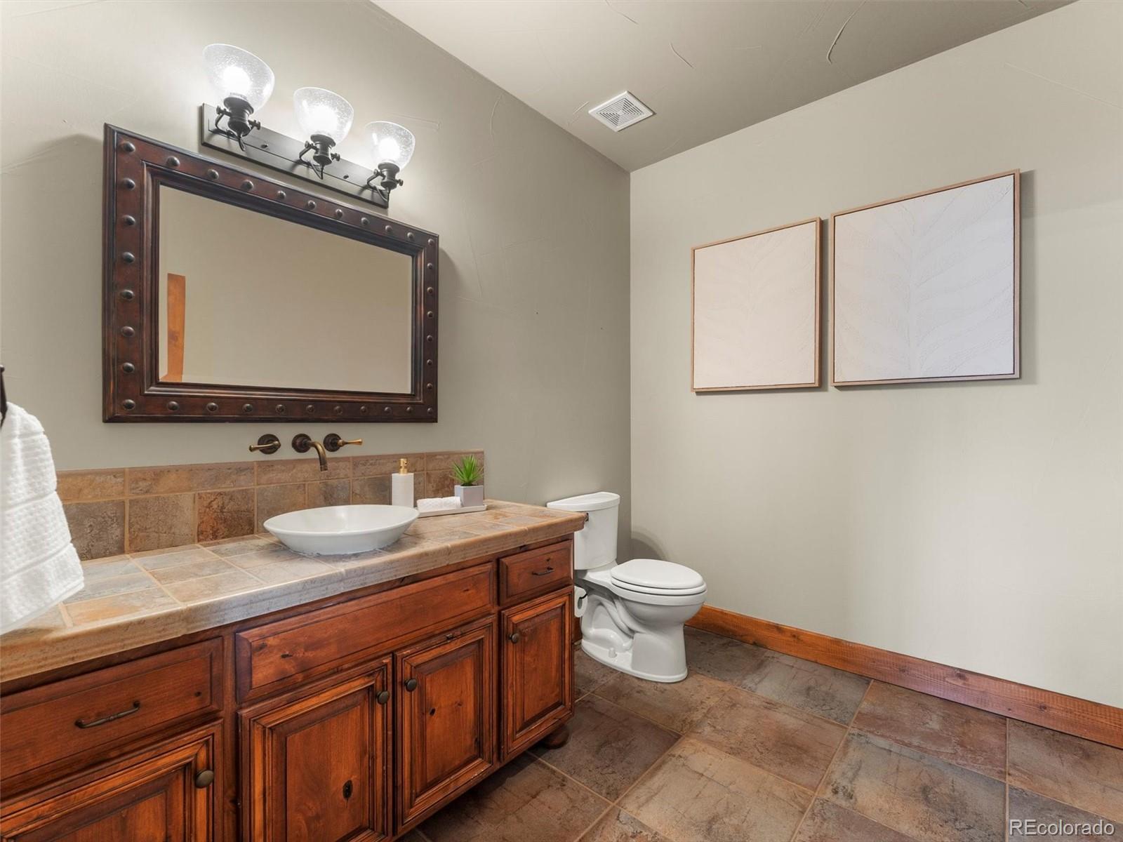 934 South Perry Park Road Sedalia, CO 80135 - Photo 29 of 48 a bathroom with a toilet sink and mirror