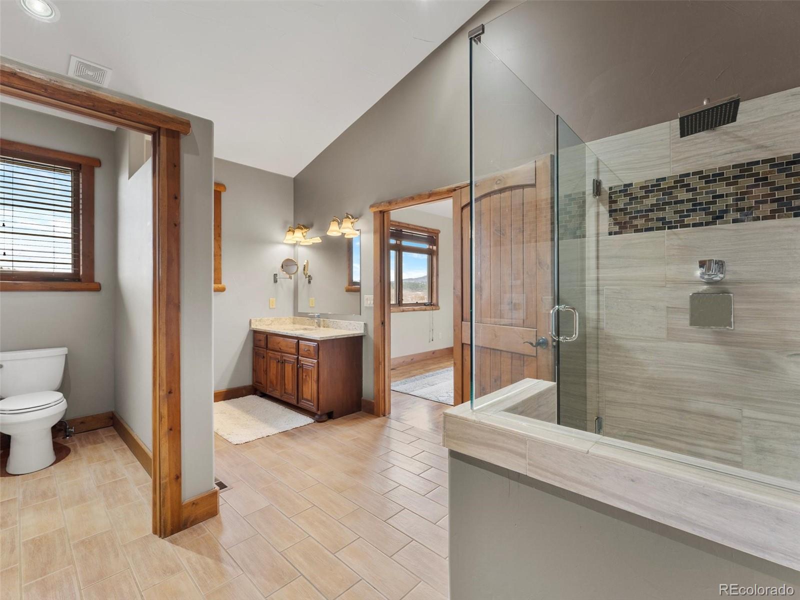 934 South Perry Park Road Sedalia, CO 80135 - Photo 33 of 48 a bathroom with a tub a sink a mirror and a shower