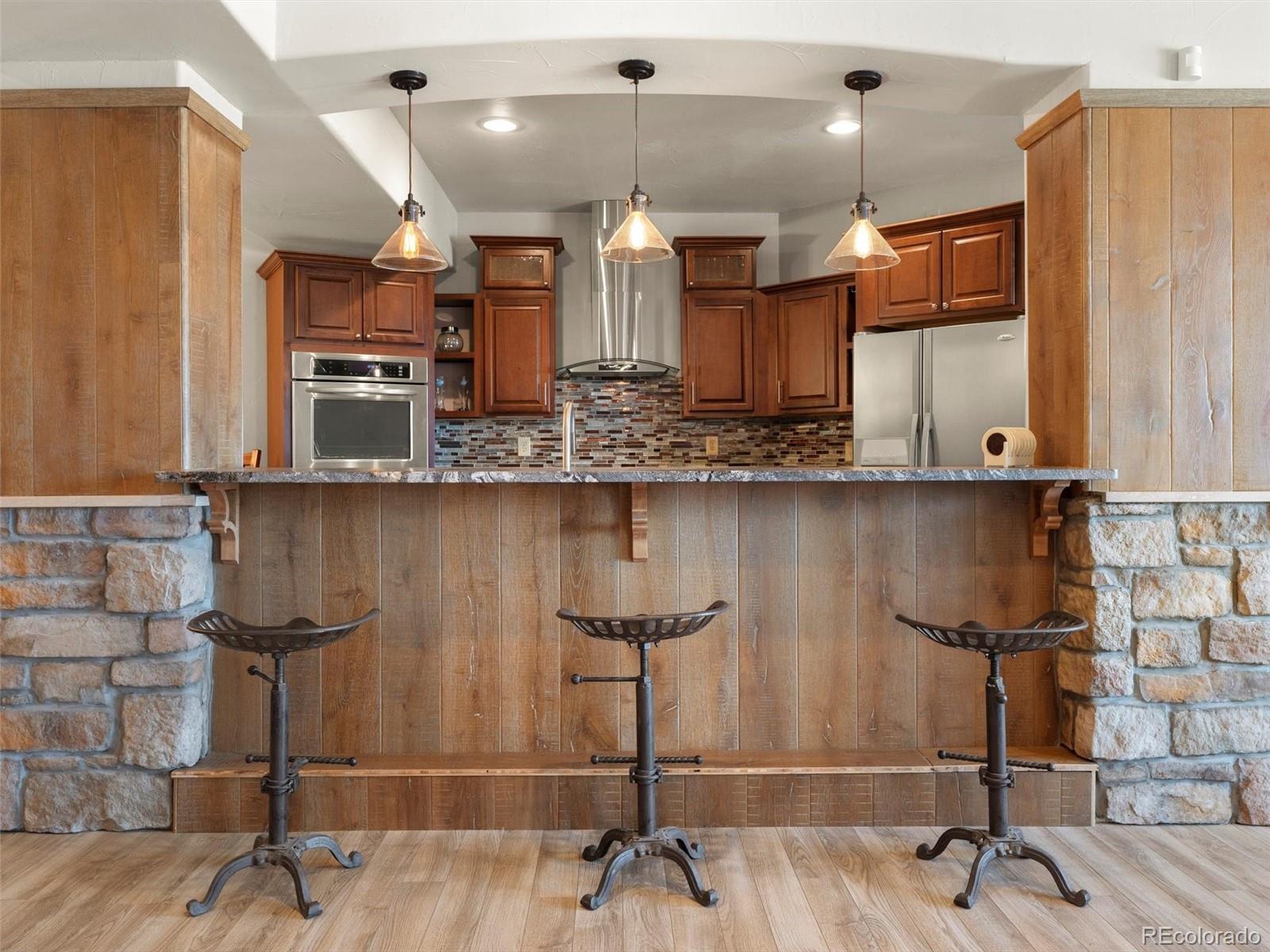 934 South Perry Park Road Sedalia, CO 80135 - Photo 37 of 48 a kitchen with stainless steel appliances granite countertop sink cabinets and wooden floor