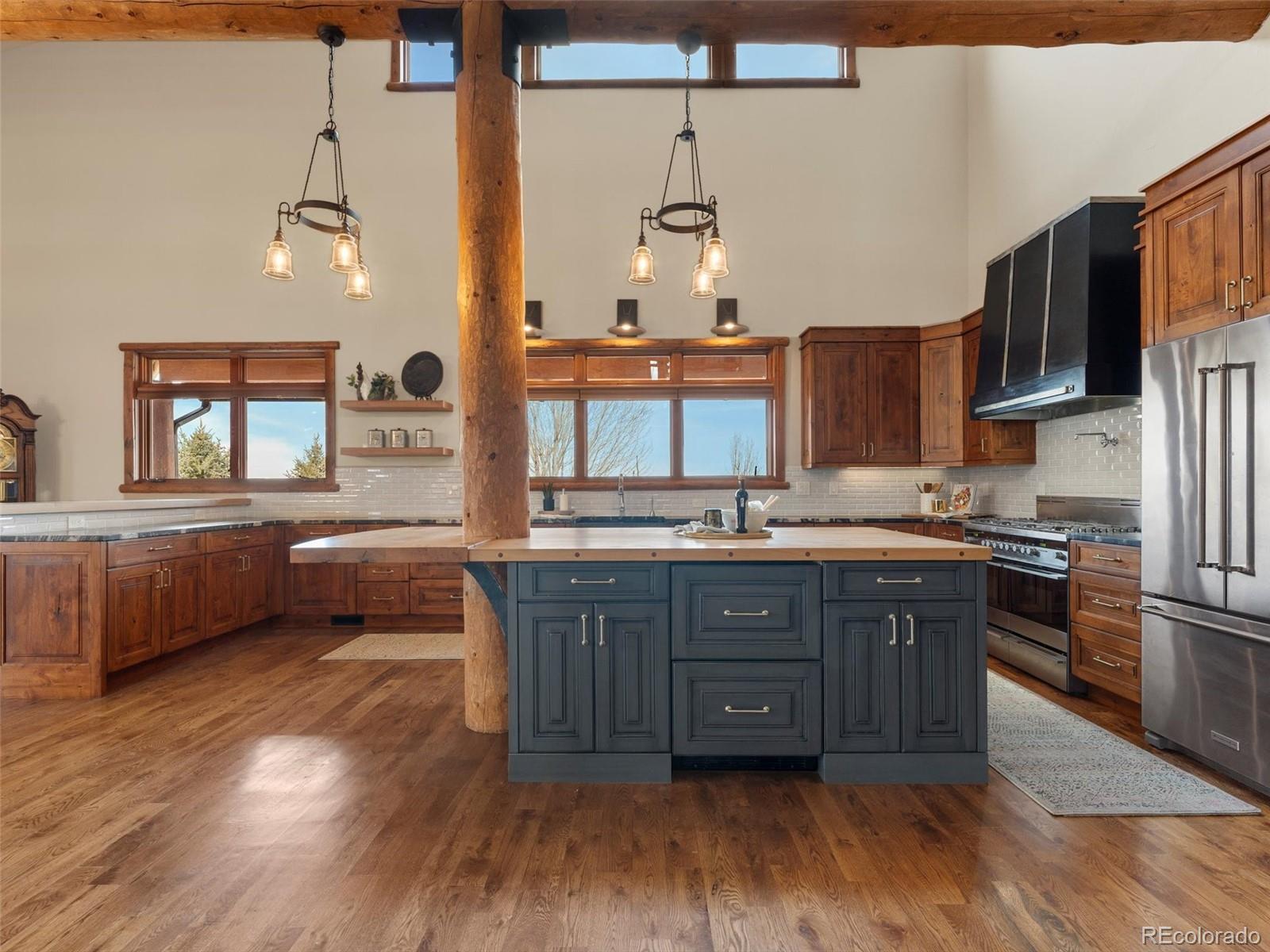 934 South Perry Park Road Sedalia, CO 80135 - Photo 10 of 48 a kitchen with stainless steel appliances granite countertop a sink a stove and wooden floor