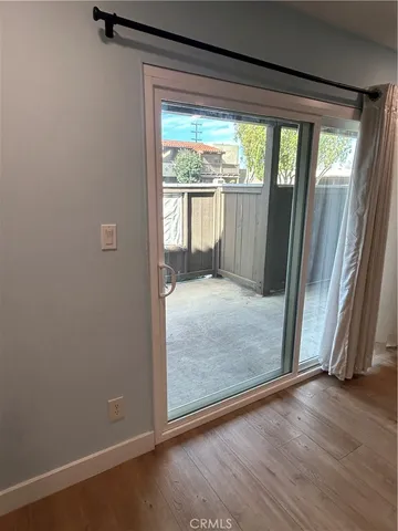 an empty room with wooden floor and front door