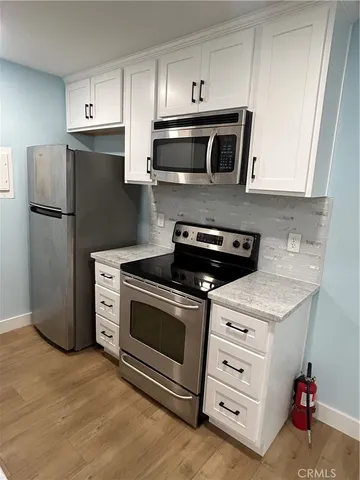 a kitchen with stainless steel appliances a stove a microwave and a refrigerator